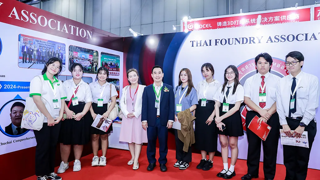 Group of ten professionals posing for a photo at an expo booth labeled 'Thai Foundry Association' with name badges visible.